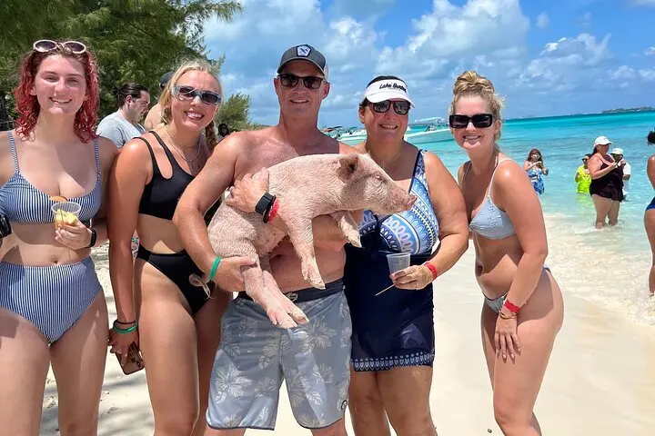 Group holding a piglet on Rose Island